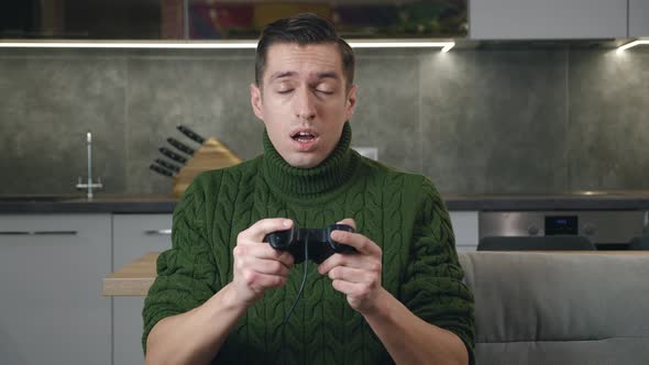 Young Male Playing a Game on the Console Controlling the Joystick Frustrated By Defeat alt