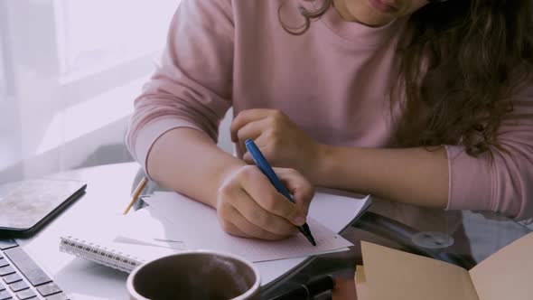 Woman Working at Home at Small Table Before Laptop