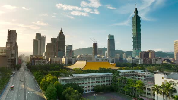 Cinematic aerial shot showing Sun Yat-Sen Memorial Hall and silhouette of skyscraper towers in Taipe alt