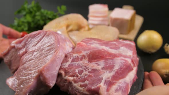 Hands Put on a Stone Plate with Pieces of Raw Meat of Veal Pork Chicken