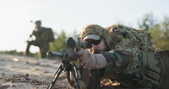 Soldier Lies on the Ground and Patrols the Area From Concealment Opens the Flap of Binoculars Looks alt