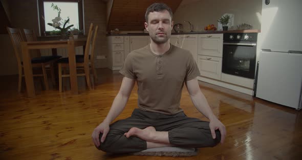 Slow Motion of Serious Young Man Meditating at Home Background