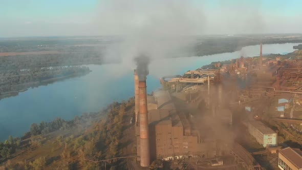 Aerial View of the Industrial Plant with Smoking Pipes Near the City alt