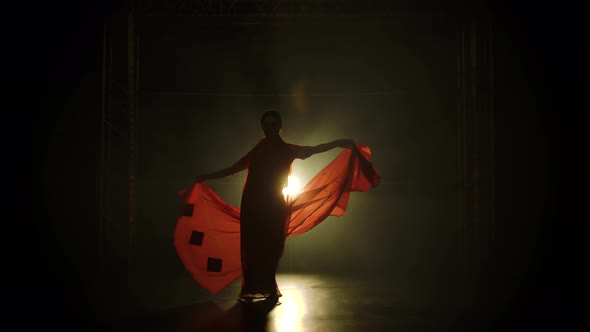 Silhouette a Young Girl Dancer in a Red Sari. Indian Folk Dance. Shot in a Dark Studio with Smoke alt