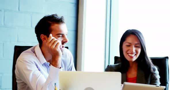 Business people discussing over digital tablet alt