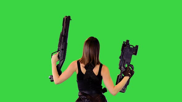 Cyberpunk Girl Walks with Machine Guns Raised Making a Series of Shots on a Green Screen Chroma Key