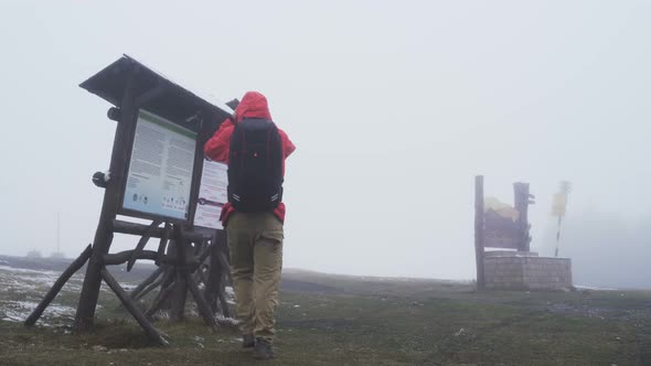 Lost Tourist Reading Map and Looking for Shelter From the Rain alt