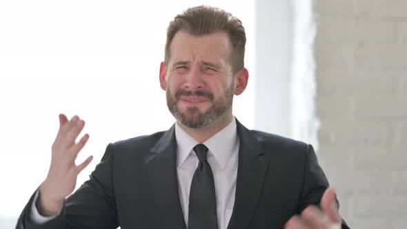 Disappointed Middle Aged Businessman Reacting to Loss alt