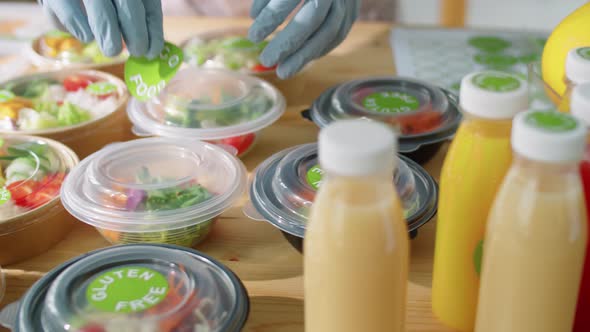 Applying Eco Food Sticker on Container with Healthy Meal alt