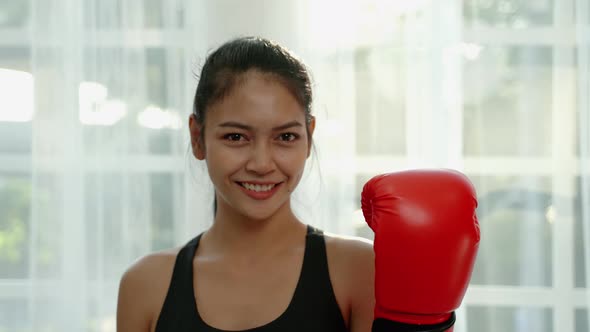 Portrait, sporty Asian woman wearing boxing gloves smiling confidently, health concept, exercise, co