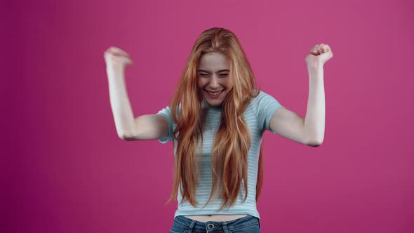 The Redhead Teenager Displays a Wide Smile Enjoying Her Results By Raising Her Hands Up Like a Real alt