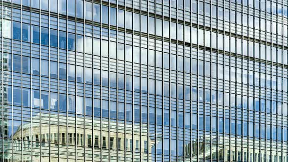 Time lapse of clouds reflecting in glass building