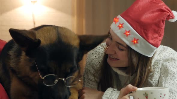 A Young Woman in a New Year's Hat Spends Time with Her Dog