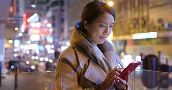 Woman use of mobile phone in city alt