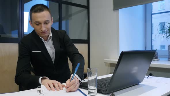  A Successful Manager Working With Papers and Laptop In Office. Young Businessman At Work. alt