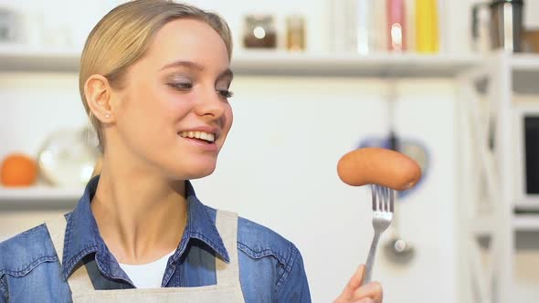 Cheerful Girl Biting Cucumber, Choosing Between Vegetable and Sausage, Vitamins alt