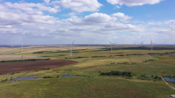 Aerial View Over the Farm Landscape and Wind Turbines Generating Clean Renewable Energy