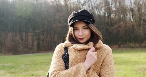 Portrait of Young Attractive Female Who Smiling and Looking at the Camera on Green Lawn. Cheerfully alt