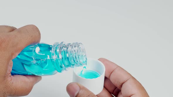 Indian Pouring Mouthwash Into Cup