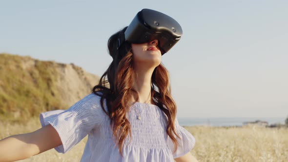 Girl with Virtual Reality Glasses in a Wheat Field in the Countryside alt