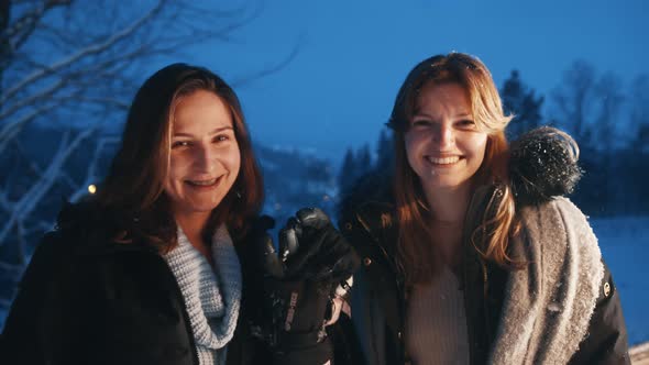 Two Happy Young Women Best Friends Waving Towards Camera and Showing Beautiful Mountain Landscape alt
