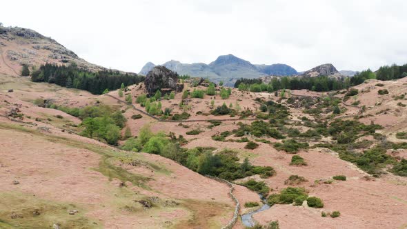 Aerial View Over Hills Towards Mountains