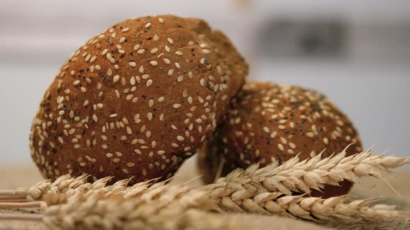 Close Up Fresh Pastries, Wheat Buns With Wheat Ears Are Spinning On The Table alt