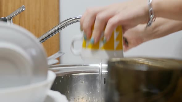 Female Hands Washed a Lot of Dishes with a Yellow Sponge Turn Off the Tap