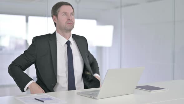 Attractive Middle Aged Businessman Standing Up and Going Away alt