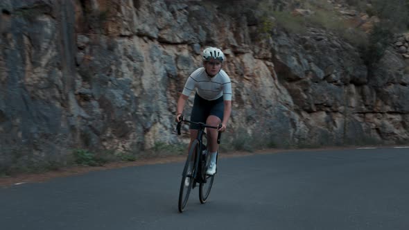 Female Pro Cyclist on Hard Mountain Road Training
