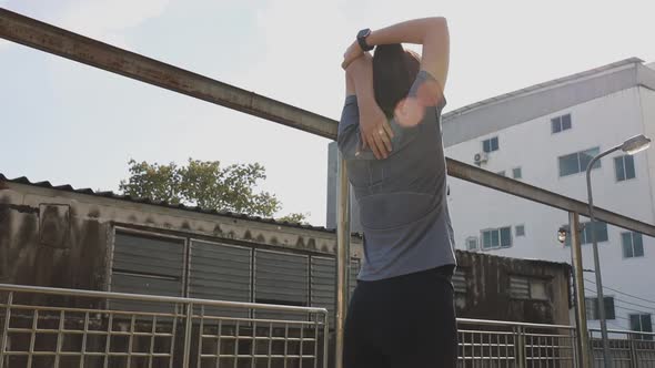 Asian woman stretching and warming before running a Jogging workout.