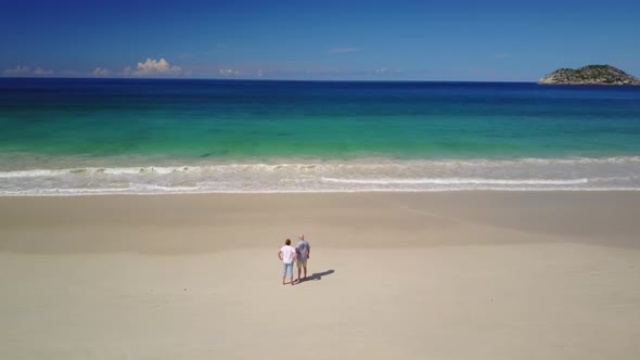 Senior Couple Standing on Sand Beach