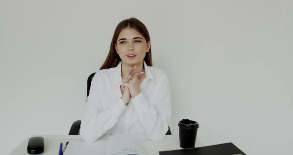 Happy Girl Talking with Gestures at Camera When Sitting at Workplace in Office alt