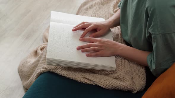 Blind Woman Reading Braille Book Sitting on Sofa Touching Letters on Sheet of Paper Using His alt