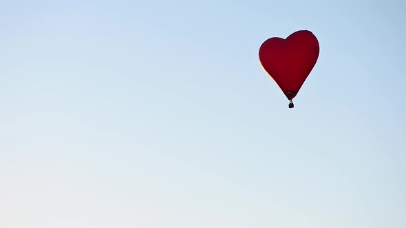 Colorful Hotair Heart Shape Balloon Flying on Sunset Over Blue Sky in Slow Motion Happy Valentines alt