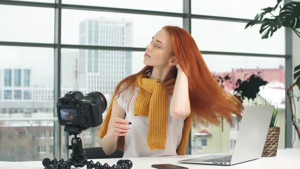 Redhead Girl Blogger Prepares for Video Recording on Camera