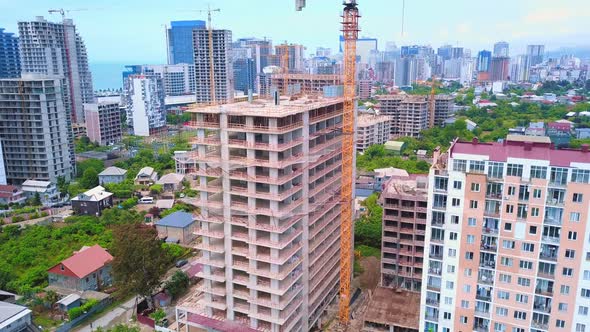 View from height of building under construction against background of sea city. alt