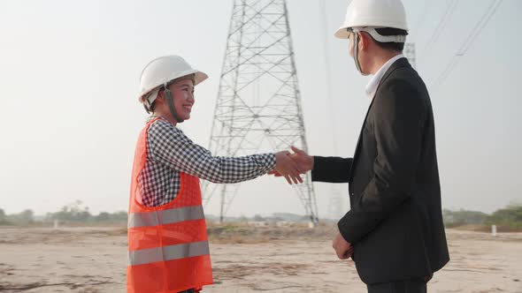 Teamwork, Leadership in construction of high-voltage power. Two Electricity engineers are handshake