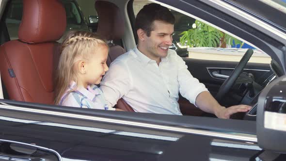 Happy Father Tells His Daughter About the Function of the Car