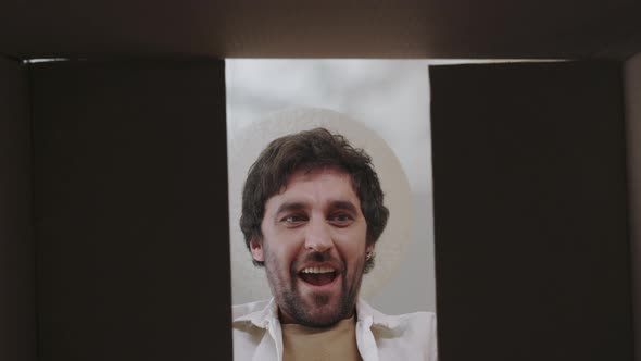 Surprised Male Customer Unpacking Cardboard Box at Home