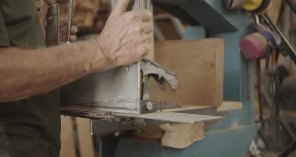 Carpenter slides in a metal plate on a saw