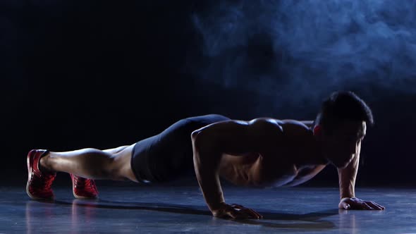 Athlete Is Pushing Away From the Floor, He Is Purposeful and Persistent. Black Smoke Background alt