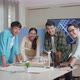 Asian Engineers Group Smiling To Camera While Working About Small House Model With Solar Panel - VideoHive Item for Sale