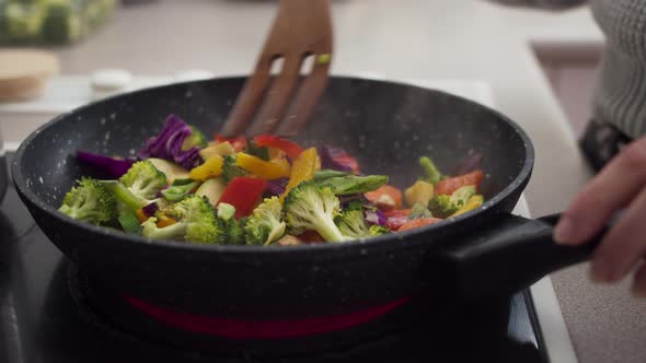 Preparing vegetables on a frying pan for healthy vegan dinner