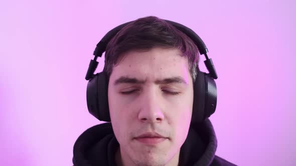 A Man Listens to Music on His Headphones and Sings Along alt