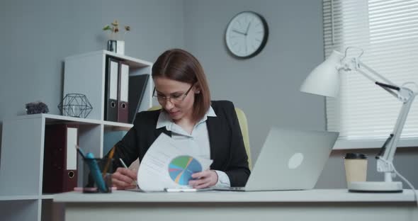 Smile Business Woman Sitting on Her Desk Holding a Pen Working with Documents Sign Up Contract