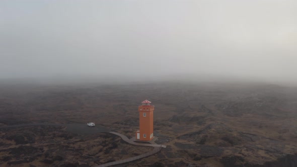 Flying Over Orange Svortuloft Lighthouse Near Rocky Cliffs