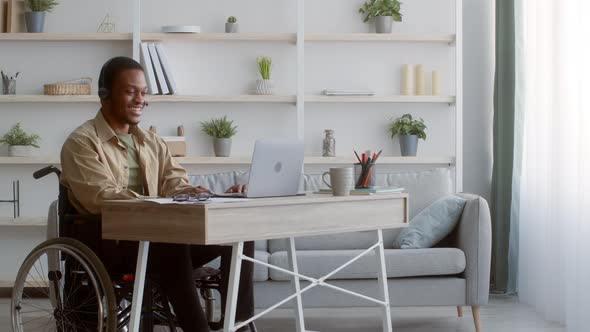 Disabled Black Man In Wheelchair Video Calling Using Laptop Indoors alt