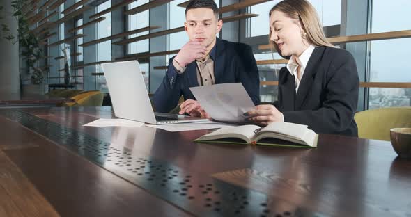Man and a Woman Discussing Work in the Brightly Lit Modern Office. Concerned Male and Female Working alt