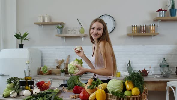Girl Recommending Eating Raw Vegetable Food. Showing Cauliflower in Hands. Weight Loss, Diet Concept alt